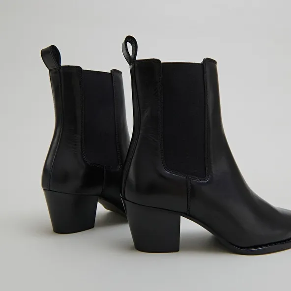 Ankle boots with beveled heels and pointed toes in black leather